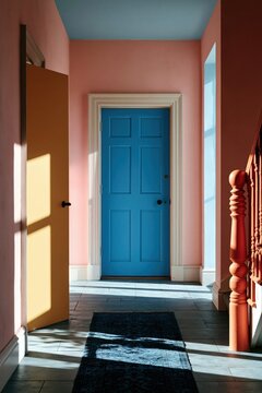 Centered blue panel door in sunlit pink hallway with yellow side door and decorative wooden banister for interior design background and poster