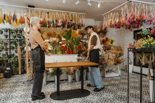 Two young florists talking together in a colorful flower shop