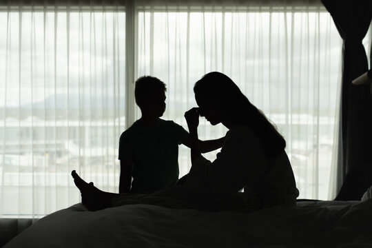 Stressed Mother Comforted by Son During Emotional Family Crisis at Home
