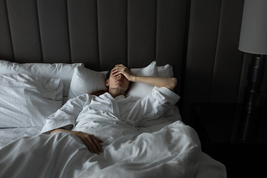 Exhausted Woman Lying in Bed Struggling With Stress and Emotional Burnout
