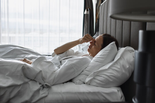 Tired Woman Rubbing Eyes While Waking Up in Bed in the Morning
