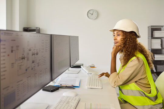 Engineer woman monitoring safety technology computers controlroom. In control room the operator reviews dashboards on monitors to ensure industrial analysis. Clear concept of monitoring safety.
