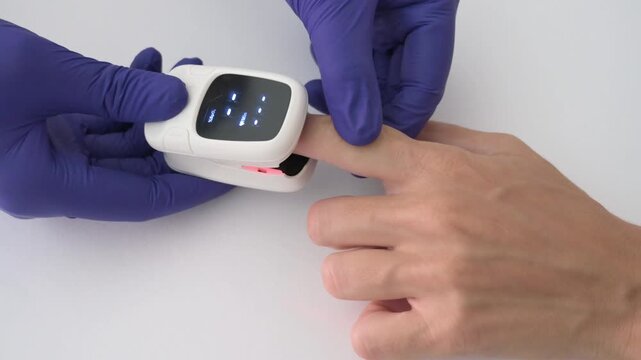 Medical professional placing pulse oximeter on patient finger for oxygen test