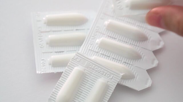 Close up of hand touching generic unbranded medicine suppository strip