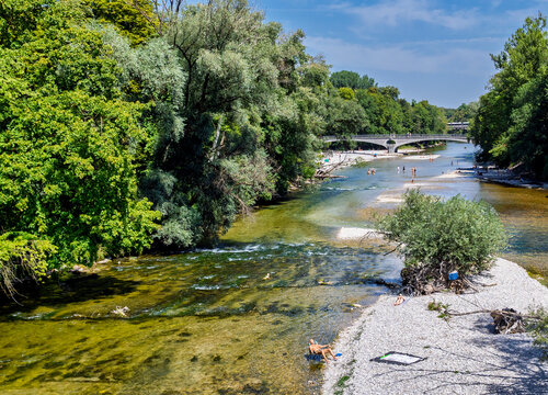 Menschen erfrischen sich am Ufer der k&uuml;hlen Isar an einem hei&szlig;en Sommertag, M&uuml;nchen, Oberbayern, Bayern, Deutschland