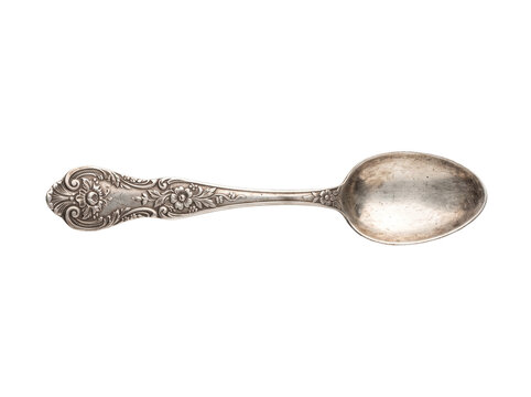 Vintage silver spoon antique silverware isolated on black background, ornate floral engraved silver teaspoon, classic elegant cutlery flatware object for culinary and dining design concepts.
