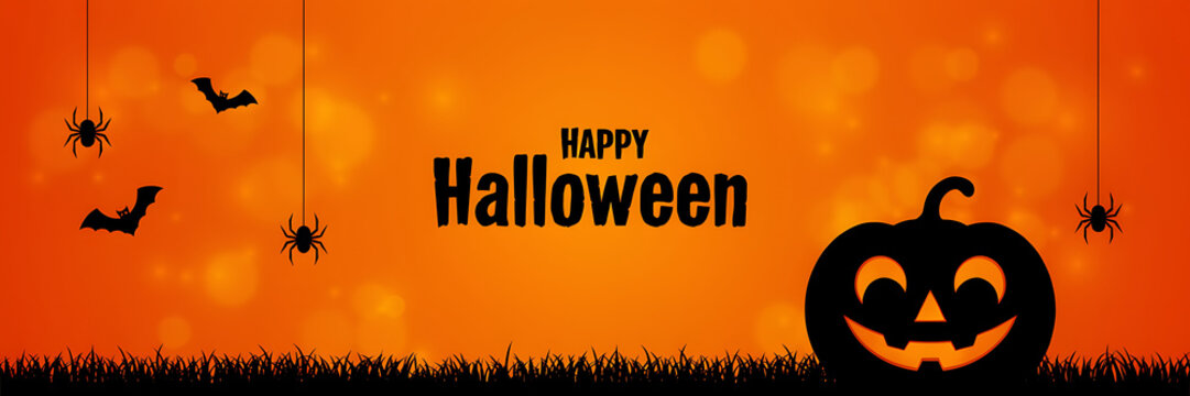 Happy halloween banner with silhouette of a smiling jack o lantern, hanging spiders, and bats against an orange blurred bokeh background