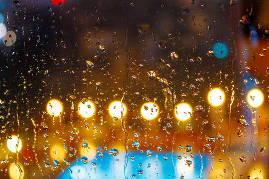 rain behind the hotel window. raindrop on the glass at night. blurred background abstract wallpaper