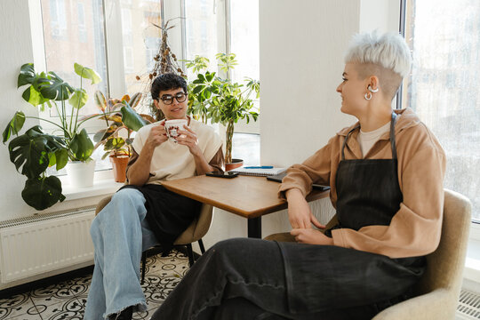 Two young florists talking together in a colorful flower shop