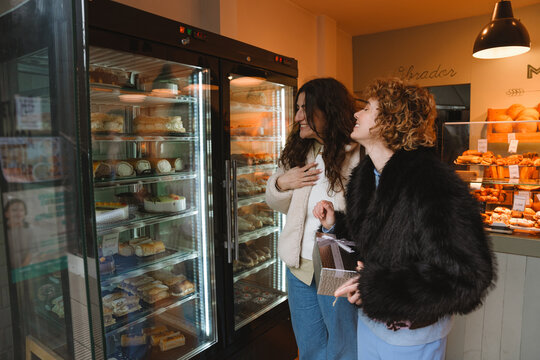 Two female friends choosing cake during a birthday celebration