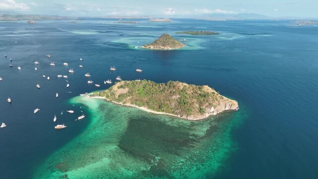 Aerial view of Pulau Kelor surrounded by turquoise waters and boats in Komodo, East Nusa Tenggara, Indonesia.