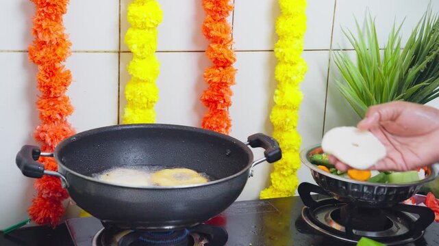 Medu vada frying in a traditional iron kadai for a festive meal during diwali festival