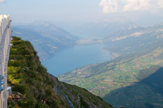 Sweeping alpine landscape overlooking Lake Thun, green valleys and Bernese Oberland mountains in Switzerland.