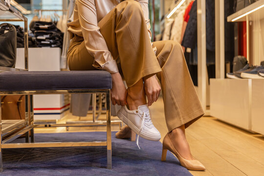 Young pretty woman trying on new shoes in a fashionable boutique