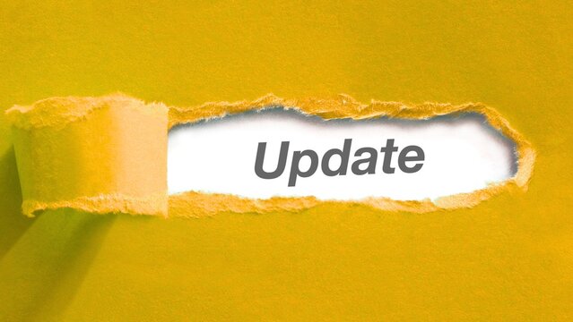 Torn yellow paper revealing word update underneath concept of news