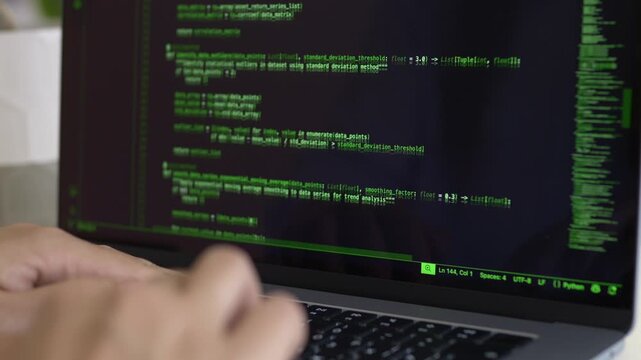 Close view of terminal interface with developer hands near keyboard. AI assisted coding, command line workflow and technical software development concept.