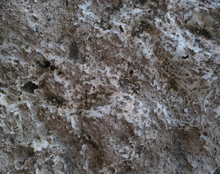 background texture of an old, rough, and uneven wave-like concrete wall. Weathered grey cement stucco surface pattern with coarse grains