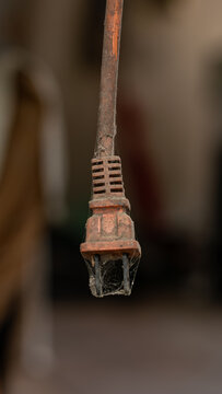 Vintage hanging electrical extension cord with rusty metal socket and cobwebs