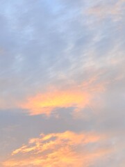 Fototapeta premium Glowing Orange Clouds Among Soft Gray Layers in a Vertical Sunset Sky