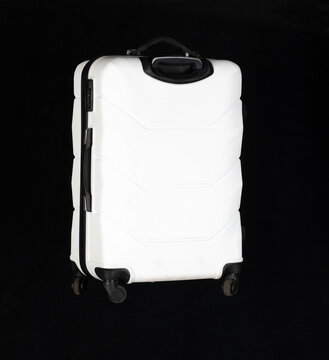 White travel suitcase isolated on black background