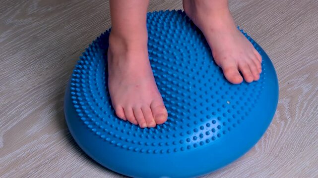 Close-up of children's feet standing on sensory balance dome while maintaining stability Educational activity improving balance, coordination, proprioception, posture Motor skills Sensory development