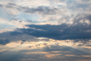 Obraz premium Sun rays breaking through dark clouds creating dramatic atmosphere
