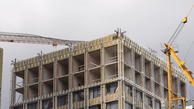 Reinforced concrete building frame under construction with tower cranes showing structural engineering, large scale construction methods and modern development process