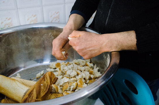 Close up of anonymous hands breaking bread for traditional Tunisian soup