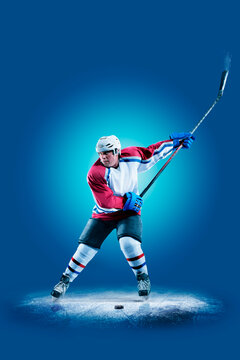 Hockey. Professional hockey player isolated on blue background. Hockey player in action. Hockey concept. Sport