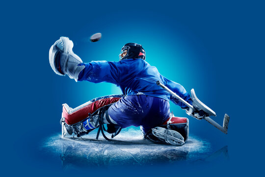 Hockey. Professional hockey player isolated on blue background. Hockey player in action. Hockey concept. Sport