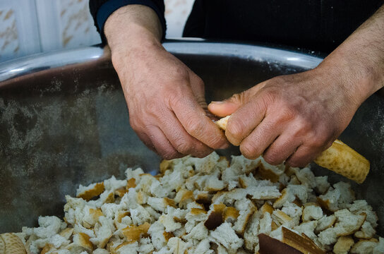 Close up of anonymous hands breaking bread for traditional Tunisian soup