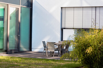 White office building exterior with table and chairs in front © FotoKachna