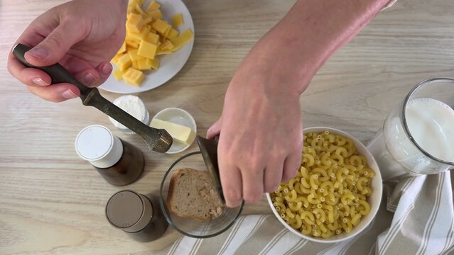 Close up shot of hands preparing snack food on a light wooden surface, showing flour residue around ingredients, natural daylight illuminates the scene, perfect for cooking or baking content
