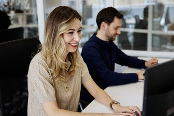 Fototapeta premium Two coworkers using computers during a collaborative office meeting