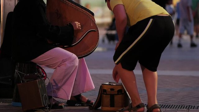 Street musician playing a bandura for pedestrians