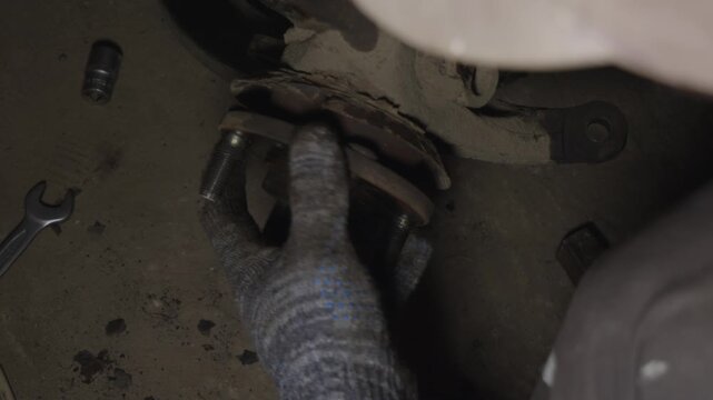 Professional mechanic wearing gloves installing a new wheel hub assembly on a car during a suspension repair service, meticulously ensuring the proper fitment for optimal performance