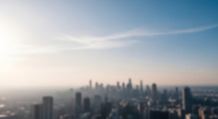 Fototapeta premium City skyline rises under a clear horizon during a bright hazy day in a blurred panorama.