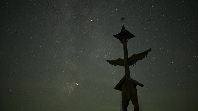 Milky Way and Meteor Shower over Wooden Wayside Cross and People Relaxing under Starry Night Sky
