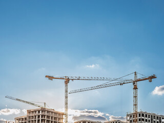 High rise residential building construction site with tower cranes against blue sky with copy space © LemPro Filming Life