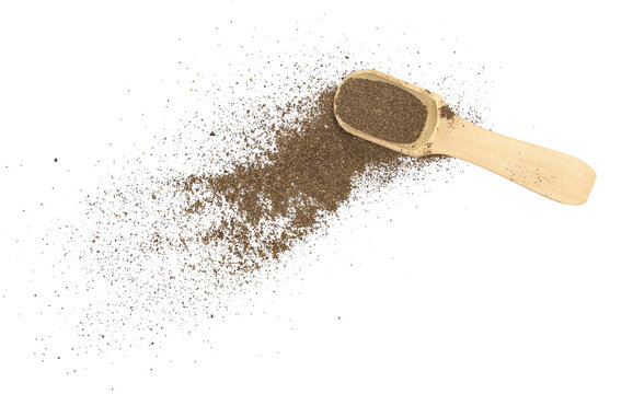 Minced black pepper in wooden spoon, ground peppercorn scattered isolated on white background, top view