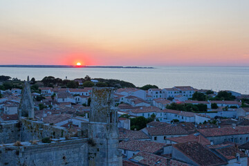 Saint-Martin-de-Ré au coucher du soleil offre un spectacle magique, où la lumière dorée illumine les fortifications de Vauban, le vieux port et les reflets paisibles de l'océan. © bru greg