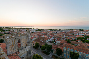 Saint-Martin-de-Ré au coucher du soleil offre un spectacle magique, où la lumière dorée illumine les fortifications de Vauban, le vieux port et les reflets paisibles de l'océan. © bru greg