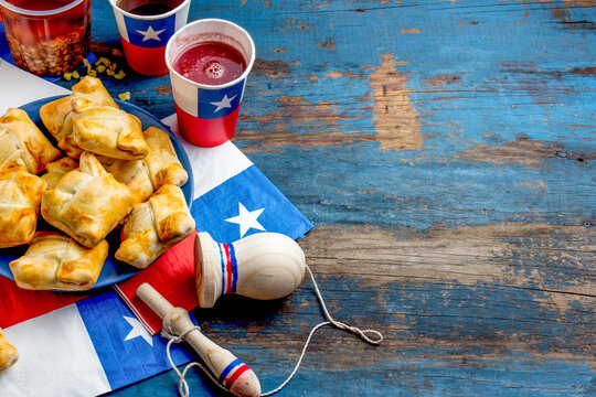 Chilean independence day concept. fiestas patrias. Chilean typical dish and drink on independence day party, 18 september. Mini empanadas, wine with toasted flour, chicha and tipical play emboque