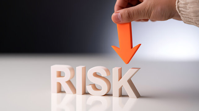 Human hand place orange arrow down on RISK word, illustrating concept of risk reduction, management, and mitigation