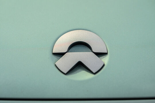 Kristiansand, Norway - June 14 2026: Close up of Nio emblem on matte green car hood.