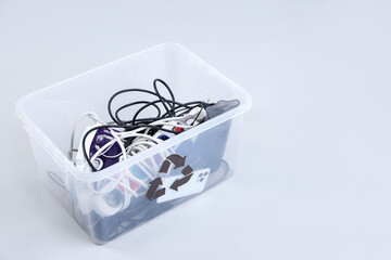 Fototapeta premium Plastic container full of broken appliances for recycling on white background, closeup. Space for text
