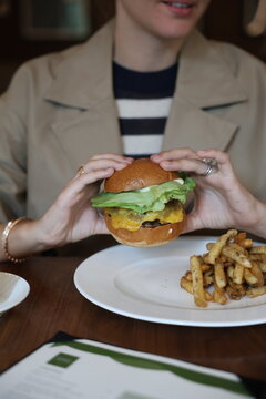 Woman Holding Fresh Burger with Both Hands