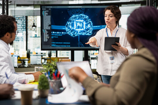 Manager presents an artificial intelligence plan to increase business productivity, discussing a software development roadmap and technology strategy with colleagues in a startup office.