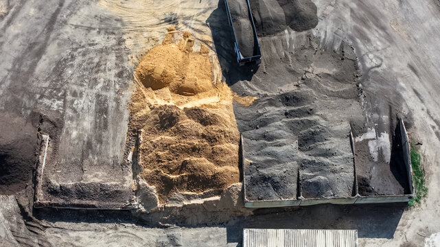 Aerial view of piles of sand and soil at construction site