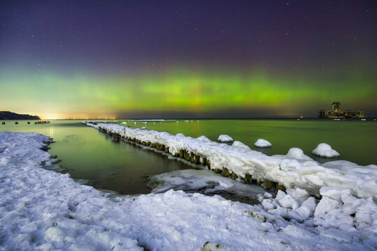 Baltic sea in Gdynia Babie Doly at winter night with northerm lights. Poland